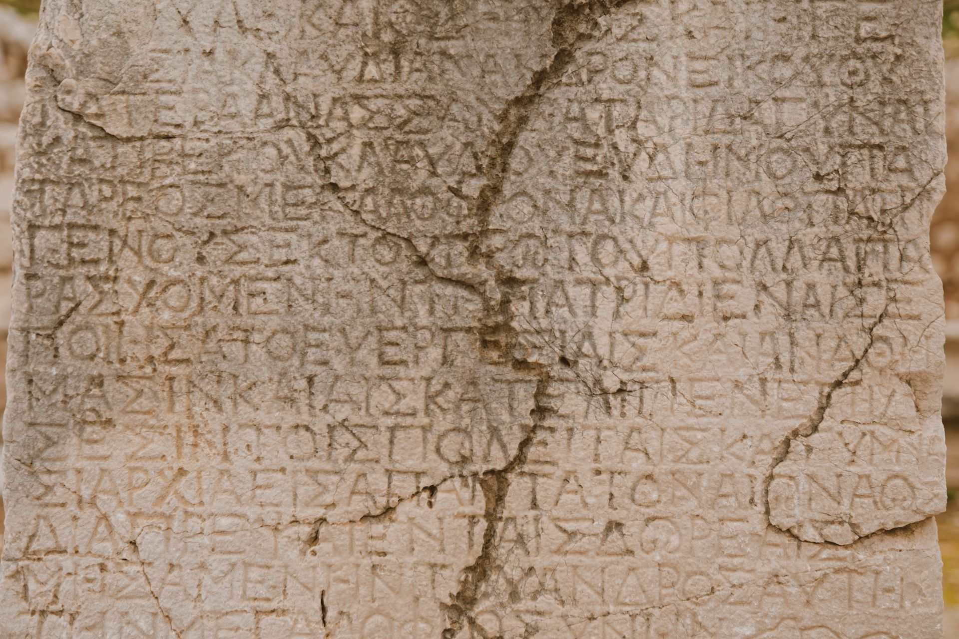 Weathered stone slab with rows of ancient carved lettering
